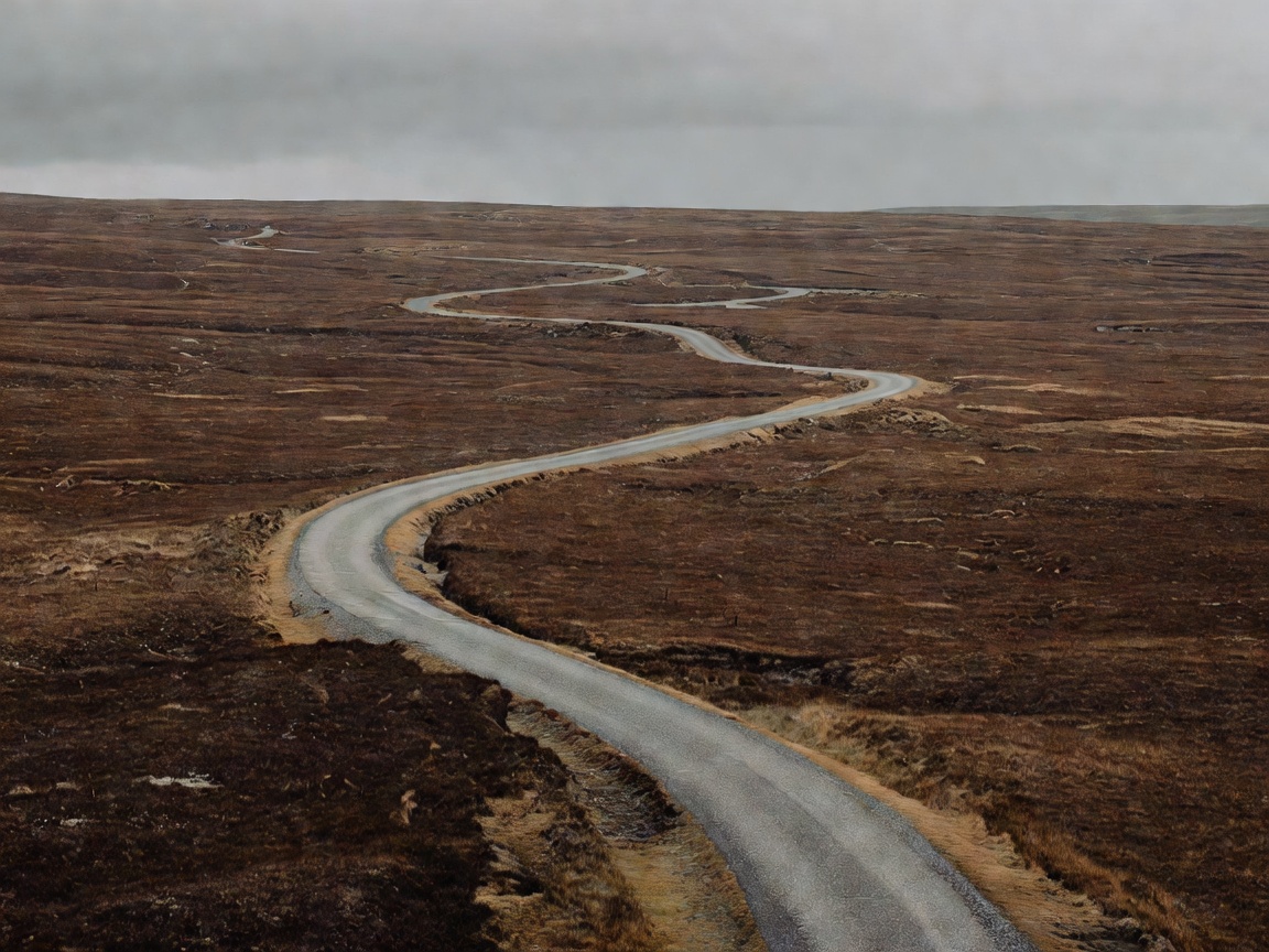 An undulating tarmac ribbon stretching across barren peat bogs in Connemara